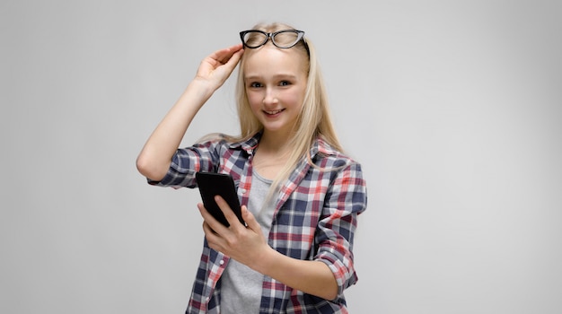 Portrait of attractive smiling sweet adorable blonde teenager girl in checkered clothes 