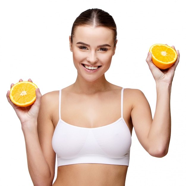 Portrait of attractive smiling woman holding orange on white