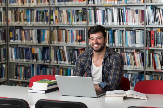 Portrait of an Attractive Student Doing Some School Work With a Laptop in the Library