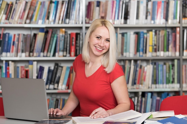 Portrait of an Attractive Student Doing Some School Work With a Laptop in the Library