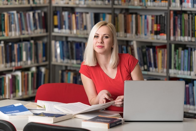 Portrait of an Attractive Student Doing Some School Work With a Laptop in the Library