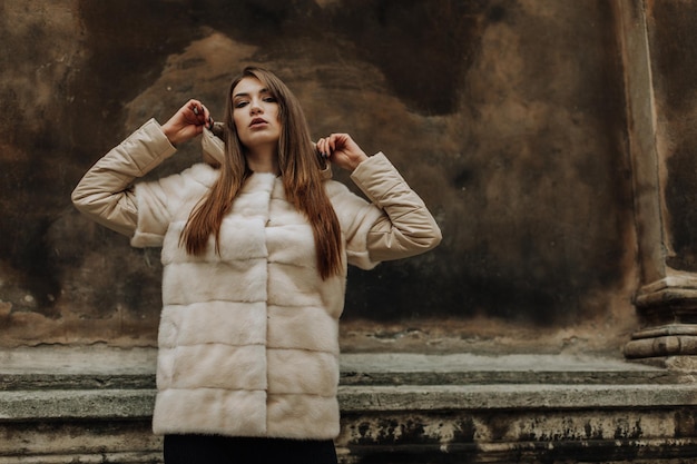 Photo portrait of attractive stylish woman in fur against grey background