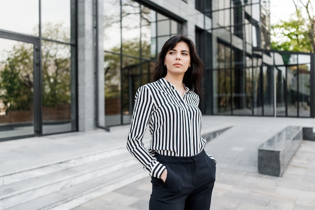 Portrait of attractive successful brunette business woman outdoors