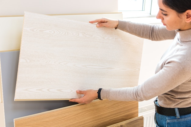 Foto ritratto di donna attraente nella costruzione di un negozio scegliendo la superficie in legno laminato per la ristrutturazione della casa e nuove idee di design.