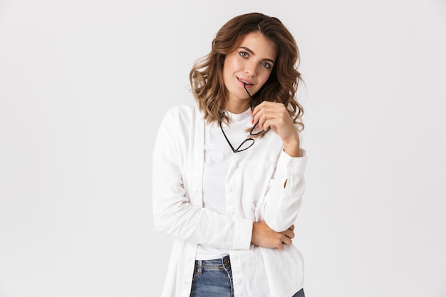 Portrait of attractive woman wearing eyeglasses smiling while standing, isolated