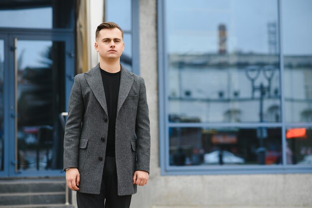 Portrait of an attractive young businessman in urban background wearing suit a necktie.