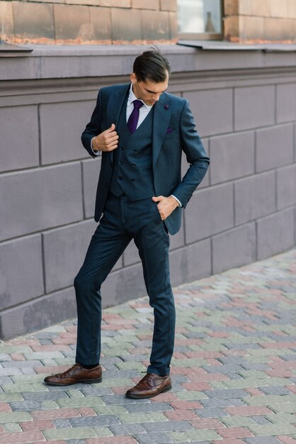 Portrait of an attractive young businessman in urban background wearing suit and a tie.