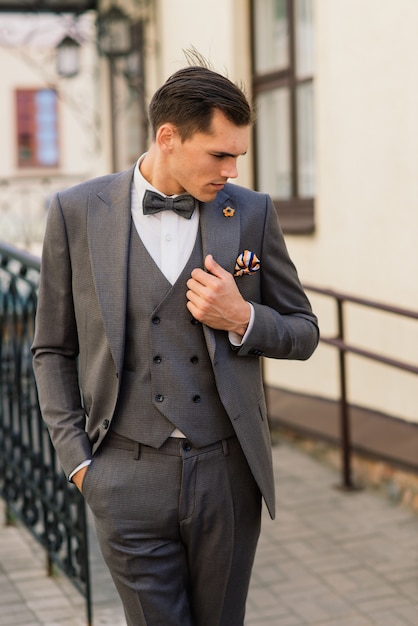 portrait of an attractive young businessman in urban background wearing suit and a tie.