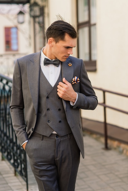 Portrait of an attractive young businessman in urban background wearing suit and a tie.