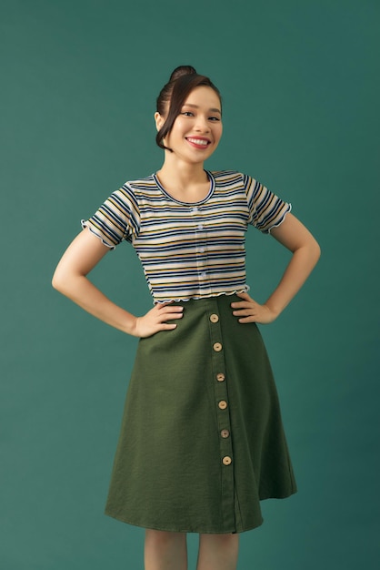 Portrait of attractive young lady smiling against green background