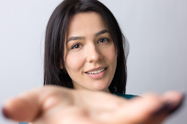 Portrait of attractive young woman wants to hug you, isolated on grey background.