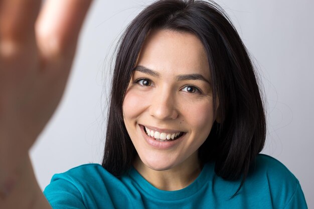 Portrait of attractive young woman wants to hug you, isolated on grey background.