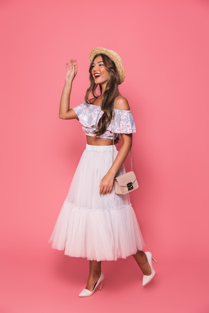 Photo portrait of attractive young woman wearing straw hat and fluffy skirt smiling and waving hand aside