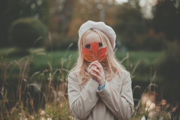 Portrait of autumn woman with fall maple leaf outdoor