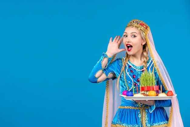 Portrait of azeri woman in traditional dress with novruz xonca blue background spring ethnic money dancers