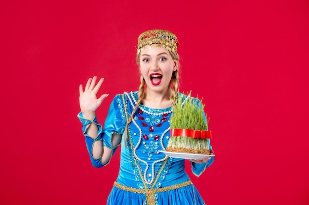 Portrait of azeri woman in traditional dress with semeni studio shot red background holiday spring ethnic novruz