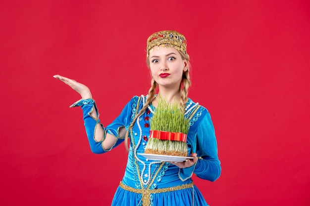 Portrait of azeri woman in traditional dress with semeni studio shot red background spring concept ethnic novruz