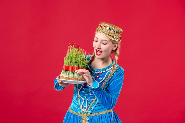 Portrait of azeri woman in traditional dress with semeni studio shot red background spring ethnic novruz holidays concept