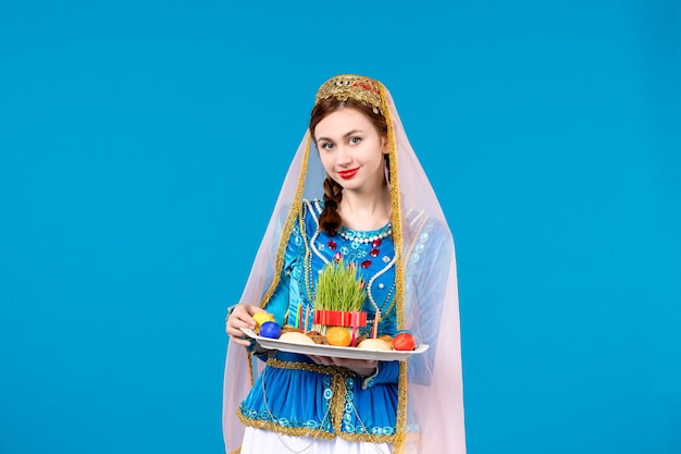 Photo portrait of azeri woman in traditional dress with xonca blue wall ethnic spring dancer