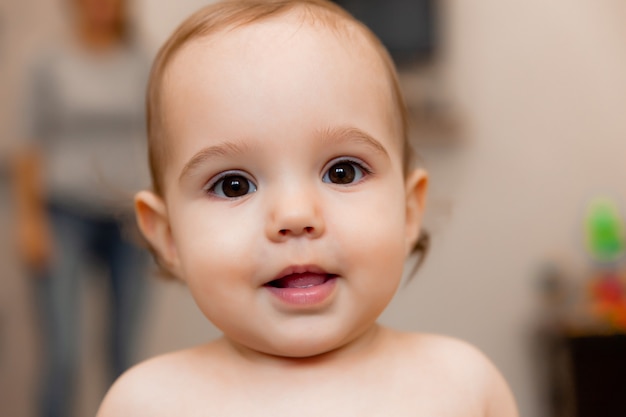 portrait of a baby 11 months old close up. cute baby smiles and looks at the camera.