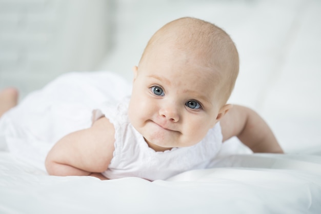 Portrait of a baby on the bed in her room