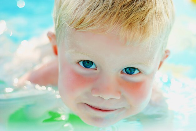 Portrait of baby boy enjoying swimming in inflatable pool