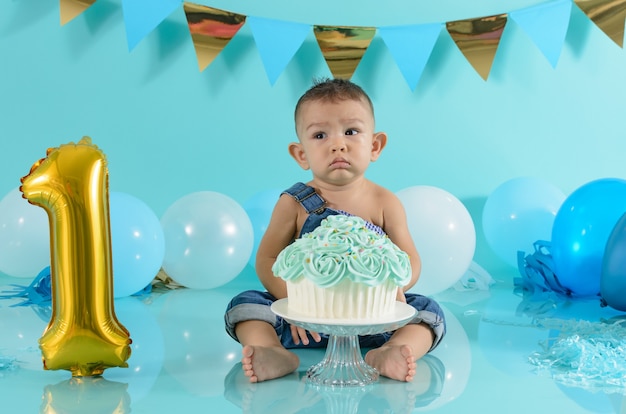 Photo portrait of baby celebrating his birthday smash cake session