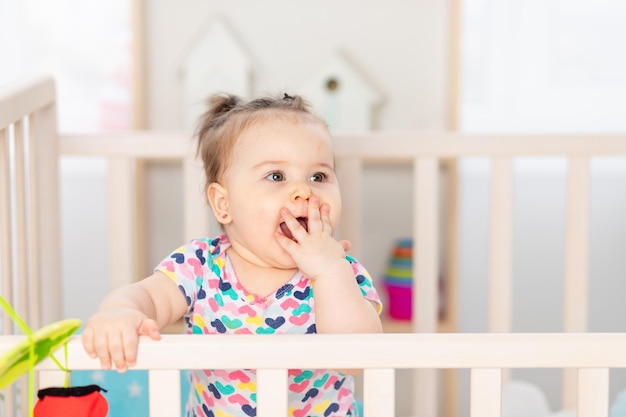 Portrait of a baby in a crib happy little baby at home