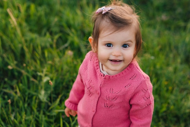 Portrait of a baby girl looking at camera having fun while exploring the nature Baby's emotions happiness funny emotions on his face