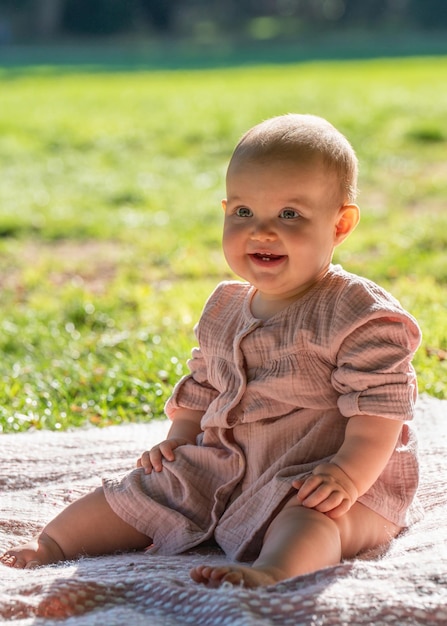 Portrait of a baby The little girl turned one year old The child smiles Sunny day in the park