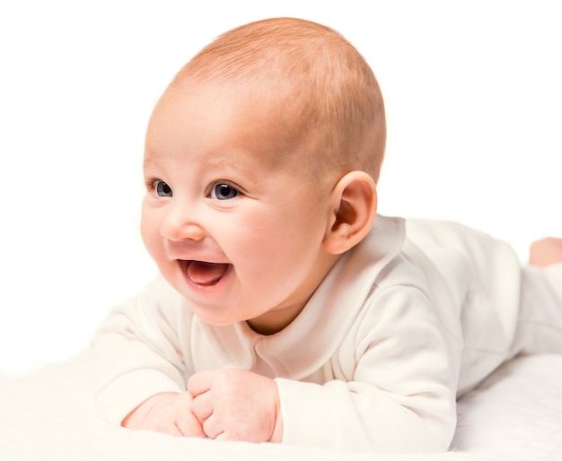 Portrait of a baby lying in bed at home.