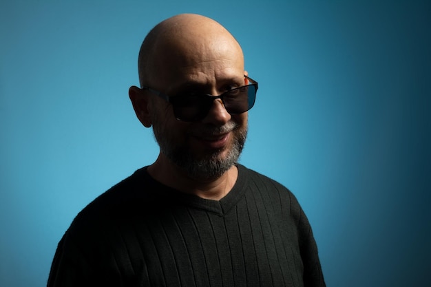 Portrait of bald and bearded mature man wearing sunglasses looking towards the camera