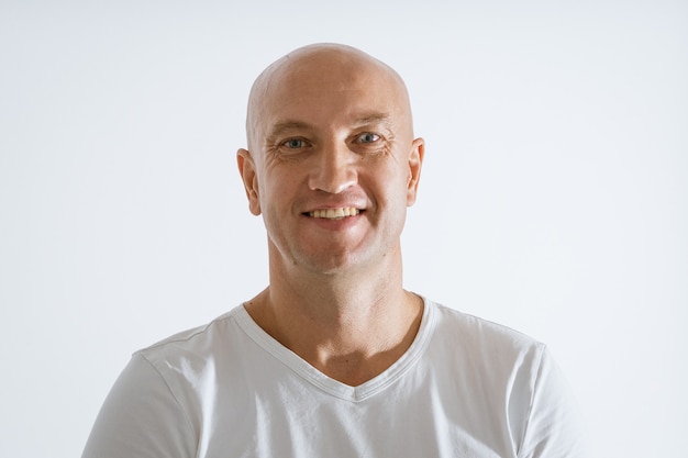 Photo portrait of a bald emotional man in a white t-shirt