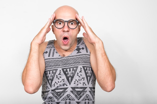 Portrait of bald nerd man with eyeglasses looking shocked