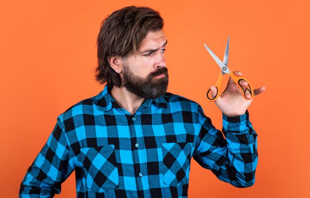 Foto ritratto di barbiere con stoppia in camicia con barbiere attrezzature utensili forbici