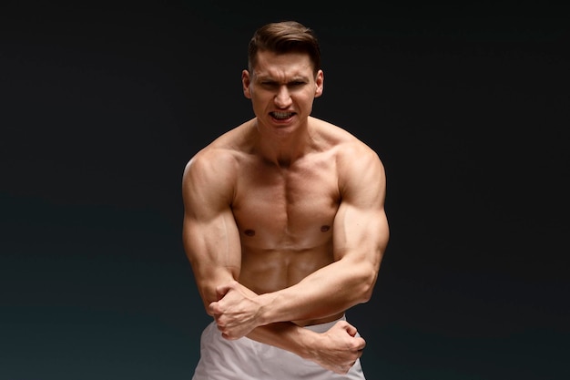 Portrait of barechested muscular sportsman isolated on black background