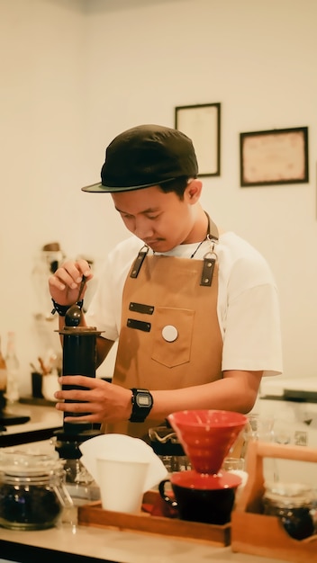 Ritratto di un barista che si concentra sulla preparazione del caffè con il metodo aeropress