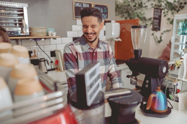 Foto ritratto di barista con i baffi in camicia che ride