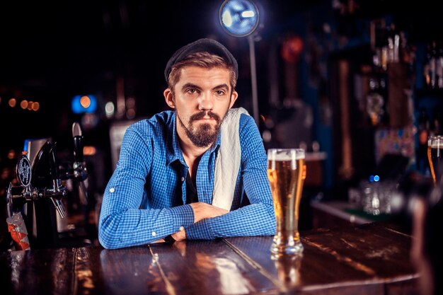 Portrait of bartender decorates colorful concoction in the nightclub