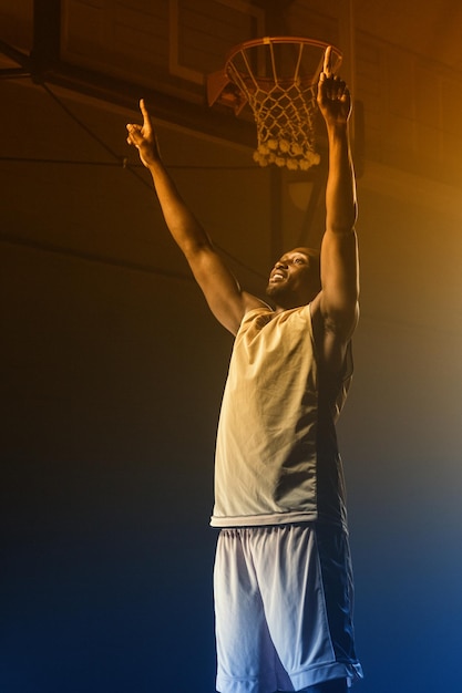 Portrait of basketball player throwing arms for the victory