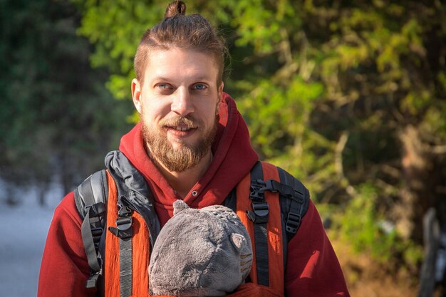 Photo portrait of bearded babywearing father with his son in baby carrier family winter hiking