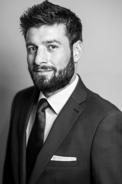 Photo portrait of bearded businessman against gray background