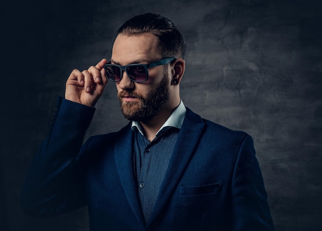 Photo portrait of bearded male in sunglasses and piercing in a nose.