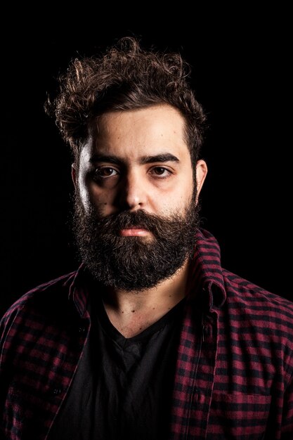 Portrait of bearded man on black background in studio photo