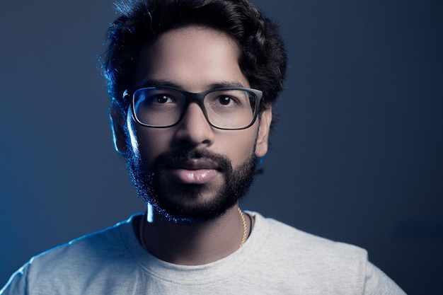 Portrait of bearded man in eyeglasses against gray background