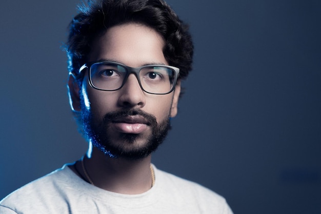 Portrait of bearded man in eyeglasses against gray background