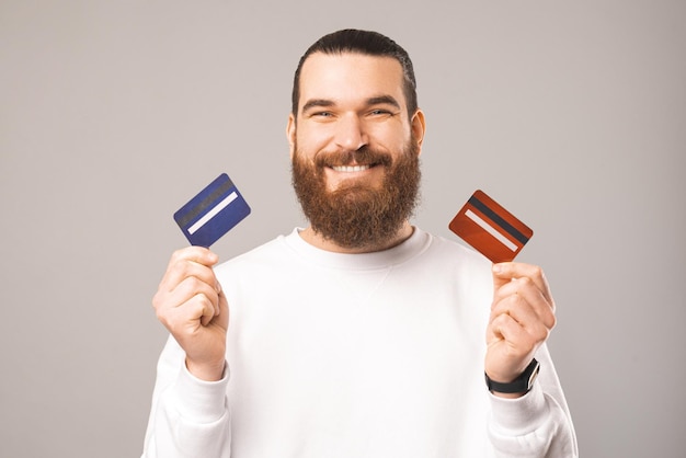 Portrait of a bearded man holding two cards waiting for you to choose