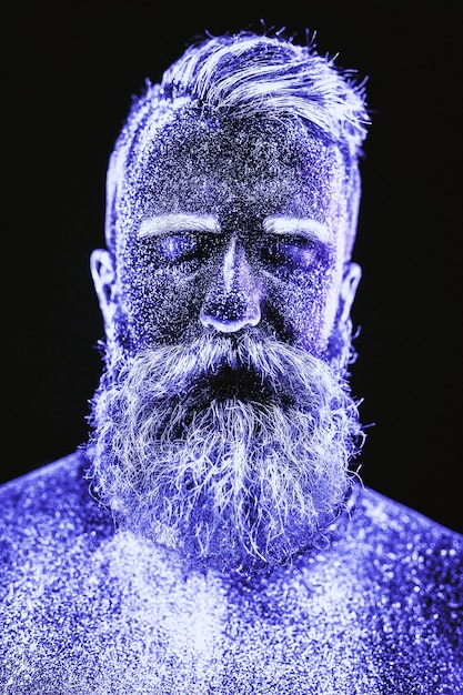 Portrait of a bearded man. man is painted in ultraviolet\
powder.
