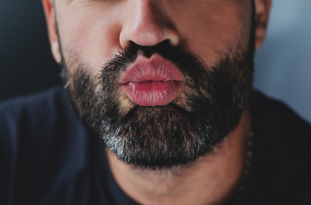 Photo portrait of a bearded man sending a kiss