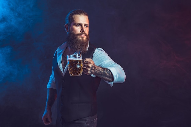 Portrait bearded man who holds tasty draft beer in hand drinking october fest concept